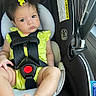 baby, child, car_seat, safety_harness, yellow_bow, polka_dot_clothing, infant, seatbelt, cute, portrait, indoors, person, face, head, skin, feet, legs, hair, expression, car_interior