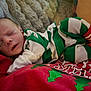 baby, newborn, sleeping, pajamas, striped_clothing, red, green, white, socks, blanket, fur, cozy, holiday, christmas, infant, child, person, cute, resting, indoor