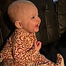 baby, child, smiling, leopard_print, onesie, clothing, sitting, couch, leather, indoor, face, head, person, happy, window, background, pattern, infant, cute, portrait
