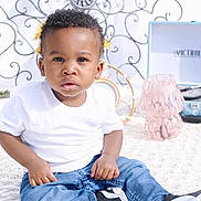 Garland is registered to the contest to win money with this photo: toddler, child, white_shirt, blue_jeans, flowers, yellow_flowers, record_player, victrola, pink_vase, blanket, outdoor, curly_ironwork, grass, shoes, cute, portrait, sitting, daylight, young_child, casual_clothing
