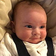 Bonnie is registered to the contest to win money with this photo: baby, infant, face, smile, clothing, straps, blanket, cozy, cute, cheeks, eyes, head, newborn, person, portrait, indoors, soft, expression, sleepwear, child