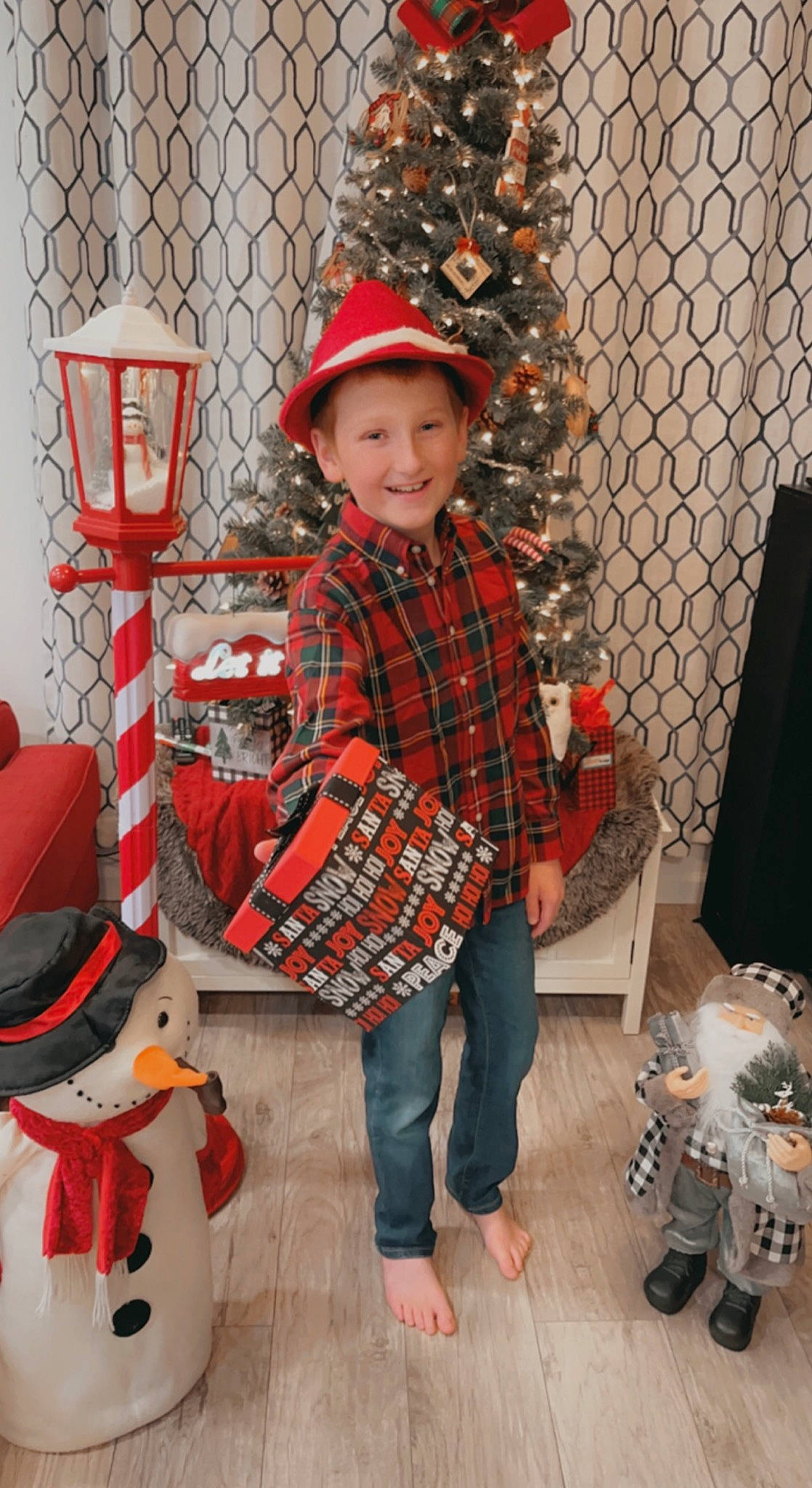 Bradyn joined the competition — help win amazing prizes! christmas, christmas_decoration, christmas_eve, christmas_ornament, clothing, event, fashion, fun, hat, holiday, human_body, joy, pattern, person, plaid, sleeve, smile, standing, tartan, textile