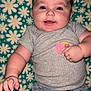 Zophia joined the competition — help win amazing prizes! baby, child, smiling, pacifier, blue_bow, gray_shirt, denim_shorts, blanket, daisy_pattern, happy, cute, infant, hand, face, portrait, clothing, lying_down, indoors, skin, headwear