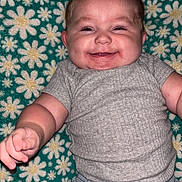Zophia joined the competition — help win amazing prizes! baby, smiling, blue_bow, blanket, daisy_pattern, green_background, shorts, gray_shirt, infant, cute, happy, child, portrait, lying_down, casual_clothing, indoor, skin, face, chubby_cheeks, playful