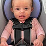 Zophia is registered to the contest to win money with this photo: baby, infant, car_seat, harness, pink_clothing, child, cute, spiky_hair, strapped_in, seatbelt, sitting, young_child, indoors, safety, red_button, clothing, person, face, expression, hands