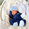 newborn, baby, infant, child, portrait, face, eyes_open, blue_outfit, tracksuit, hat, cap, nike, mittens, socks, baby_rocker, bouncer, blanket, cushion, indoor, cozy