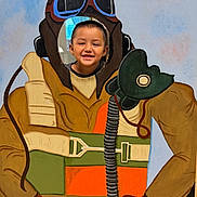 Jafet is registered to the contest to win money with this photo: child, smiling, face, cutout_board, pilot_costume, painting, hands_on_hips, playful, vintage, goggles, flight_suit, brown_gloves, orange_vest, green_belt, blue_sky_background, indoor, fun, portrait, happy, costume