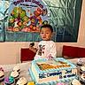 child, birthday, cake, cupcakes, frosting, party, celebration, table, chair, poster, banner, food, dessert, icing, smiling, indoor, colorful, holiday, happy, toddler