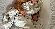 Jazer is registered to the contest to win money with this photo: baby, sleeping, blanket, brown_clothing, baby_lounger, patterned_fabric, infant, peaceful, cozy, cushion, indoors, child, resting, soft_light, cute, head, face, hand, portrait, comfort