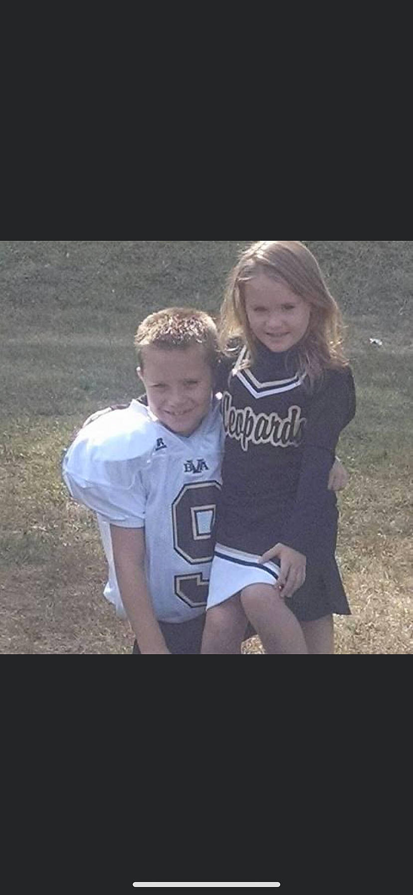 Ethan And Jaylie is registered to the contest to win money with this photo: blond, child, darkness, event, flash_photography, fun, gesture, grass, grey, happy, joy, love, people_in_nature, person, portrait_photography, sitting, sleeve, smile, soil, sportswear