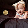 Clara joined the competition — help win amazing prizes! baby, infant, child, headband, bow, blue_eyes, expression, black_blanket, wooden_sign, four_months, portrait, cute, young_child, clothing, person, indoor, face, skin, baby_girl, background