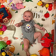 Clara joined the competition — help win amazing prizes! baby, basket, child, colorful, crawling, cute, football, happy, indoor, infant, laying_down, onesie, person, plastic_balls, play_area, play_mat, smiling, soft_toys, stuffed_animal, toys
