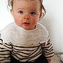 baby, child, blue_eyes, curly_hair, hair_bows, striped_sweater, white_socks, sitting, floor, indoor, portrait, cute, infant, childhood, looking_at_camera, young_child, casual_clothing, light_background, hands, feet