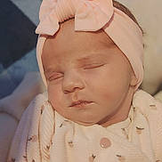 Zora participe au concours pour gagner de l'argent avec cette photo : baby, infant, newborn, sleeping, headband, bow, closeup, portrait, pink, onesie, blanket, swaddle, cheeks, eyelids, lips, soft_texture, cozy, peaceful, indoor, floral_pattern