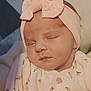 baby, infant, newborn, sleeping, headband, bow, closeup, portrait, pink, onesie, blanket, swaddle, cheeks, eyelids, lips, soft_texture, cozy, peaceful, indoor, floral_pattern