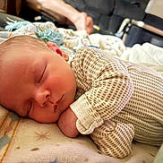 Waylon is registered to the contest to win money with this photo: baby, newborn, sleeping, blanket, onesie, infant, closeup, face, peaceful, resting, soft, cozy, indoors, person, cute, skin, head, hand, portrait, child