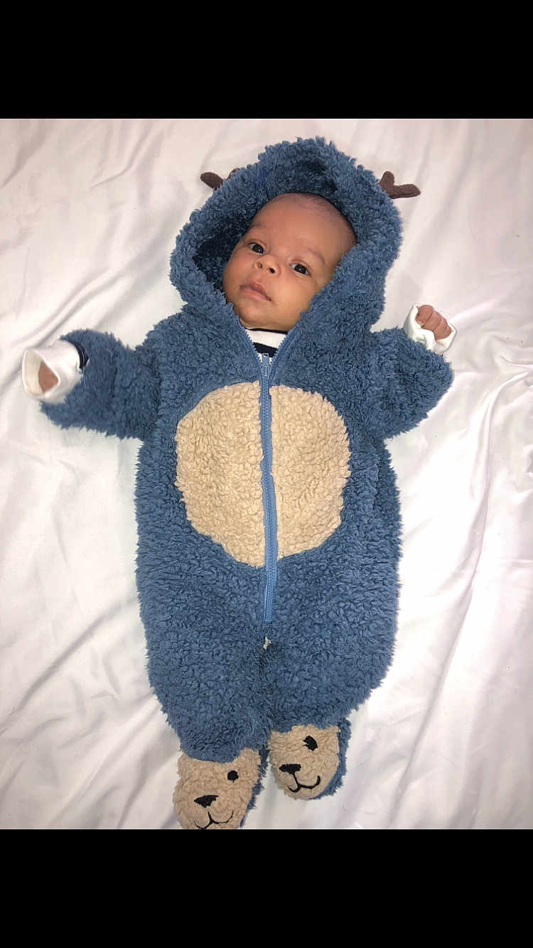 Kaïss participe au concours pour gagner de l'argent avec cette photo : baby, infant, onesie, blue, beige, fluffy, costume, bear, feet, face, expression, lying_down, blanket, white, child, cute, clothing, hood, portrait, indoor