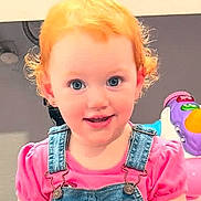 Kinslee joined the competition — help win amazing prizes! child, toddler, red_hair, blue_eyes, denim_overalls, pink_shirt, toy_car, steering_wheel, indoor, smiling, cute, curly_hair, playtime, baby, person, young_child, happy, seat, hands, face