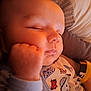 Jaxson joined the competition — help win amazing prizes! baby, sleeping, infant, onesie, dinosaur_pattern, hand, face, closeup, cozy, soft_light, child, peaceful, cute, pajamas, resting, indoors, blanket, cushion, person, portrait