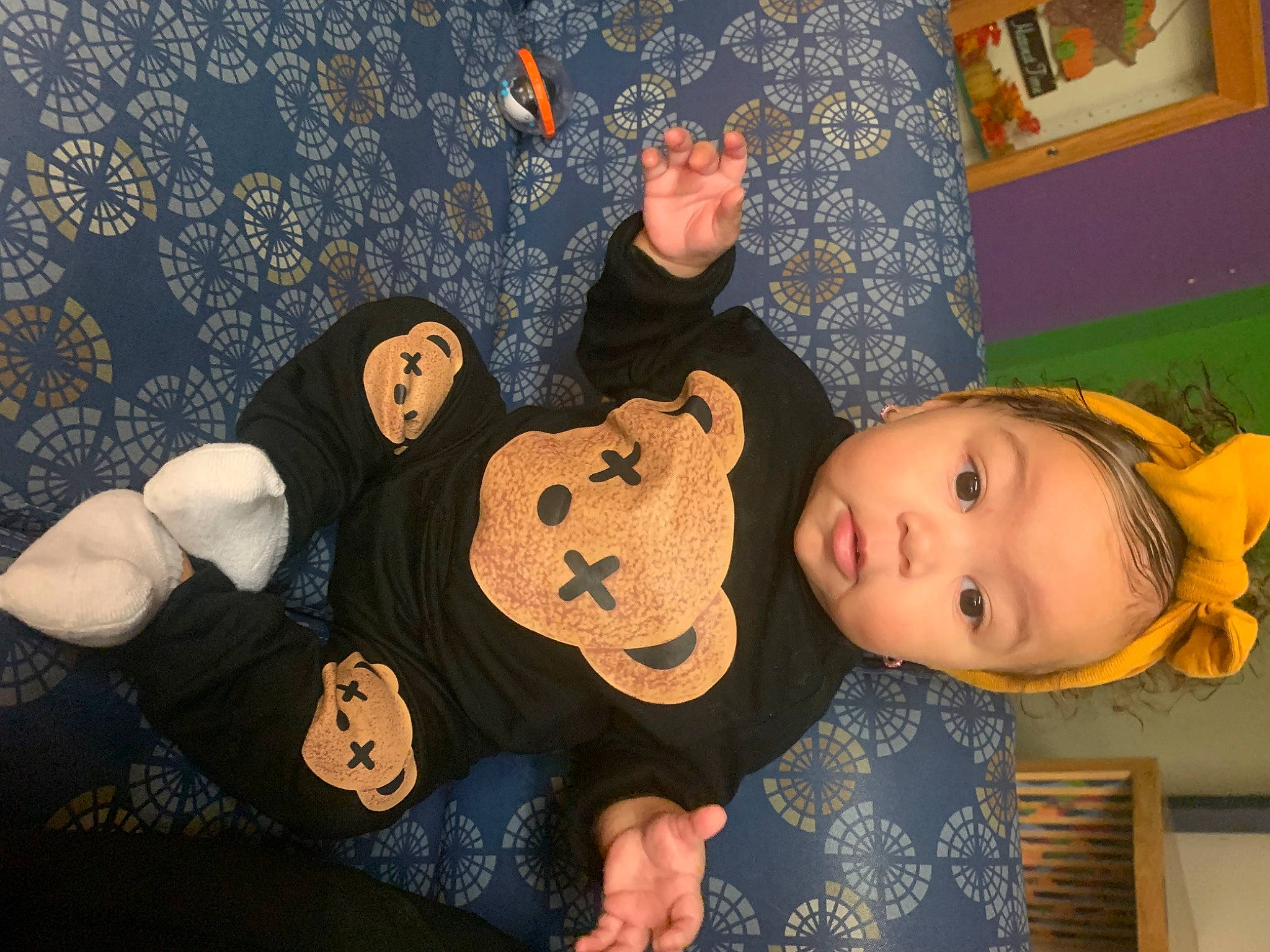 Leilani is registered to the contest to win money with this photo: baby_toddler_clothing, cheek, child, comfort, fun, gesture, happy, pattern, person, plush, room, stuffed_toy, textile, thumb, toddler, toy, wood, wrist