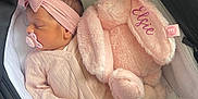 Elsie is registered to the contest to win money with this photo: baby, newborn, sleeping, pink_onesie, headband, pacifier, stuffed_animal, pink_bunny, stroller, blanket, soft_toy, infant, cute, resting, child, cozy, sleep, indoor, comfort, peaceful
