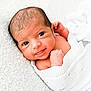 Elsie is registered to the contest to win money with this photo: newborn, baby, infant, wrapped, blanket, white, knitted, smile, face, skin, cute, lying_down, soft_texture, close_up, portrait, small_hands, young, indoors, cozy, resting