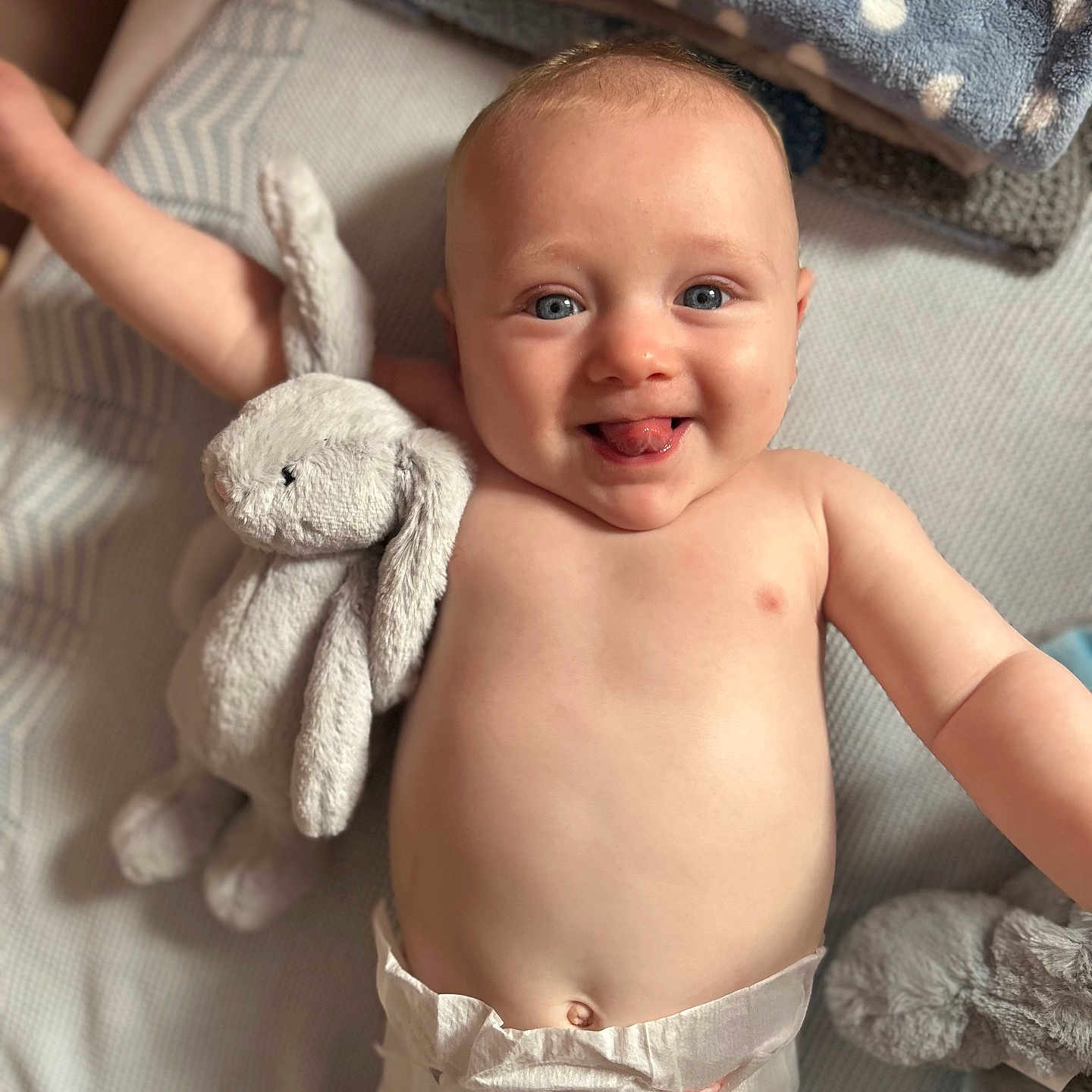Oliver joined the competition — help win amazing prizes! arm, baby, blanket, blue_eyes, bunny_toy, child, cozy, cute, diaper, face, happy, indoor, infant, lying_down, playful, plush_toy, skin, smiling, soft_toys, tongue_out