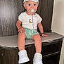 Tchad a rejoint le concours — aidez-le/la à gagner de superbes lots ! toddler, child, white_cap, pacifier, white_tshirt, tiger_print, mint_shorts, white_sneakers, bench, wooden_furniture, cushion, indoor, sitting, cute, smiling, person, young_child, footwear, casual_clothing, baby