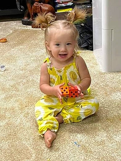 Isla is registered to the contest to win money with this photo: baby, baby_toddler_clothing, child, eye, face, facial_expression, flooring, fun, happy, head, iris, mammal, people, person, photograph, sitting, skin, sleeve, smile, standing