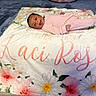 Kaci-Rose is registered to the contest to win money with this photo: baby, infant, smiling, pink_onesie, blanket, floral_pattern, name_print, lying_down, happy, cozy, indoor, soft_texture, cute, person, portrait, child, newborn, comfort, face, baby_clothing