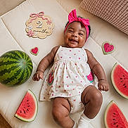 Kaci-Rose joined the competition — help win amazing prizes! baby, infant, smiling, watermelon, fruit, milestone, headband, dress, cushion, pink, cute, lying_down, chubby_arms, chubby_legs, white_socks, indoor, happy, portrait, child, two_months