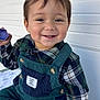 Santiago joined the competition — help win amazing prizes! toddler, child, smile, happy, overalls, plaid_shirt, toy, sitting, blanket, face, hand, outdoor, clothing, button, corduroy, person, portrait, footwear, texture, white_wall