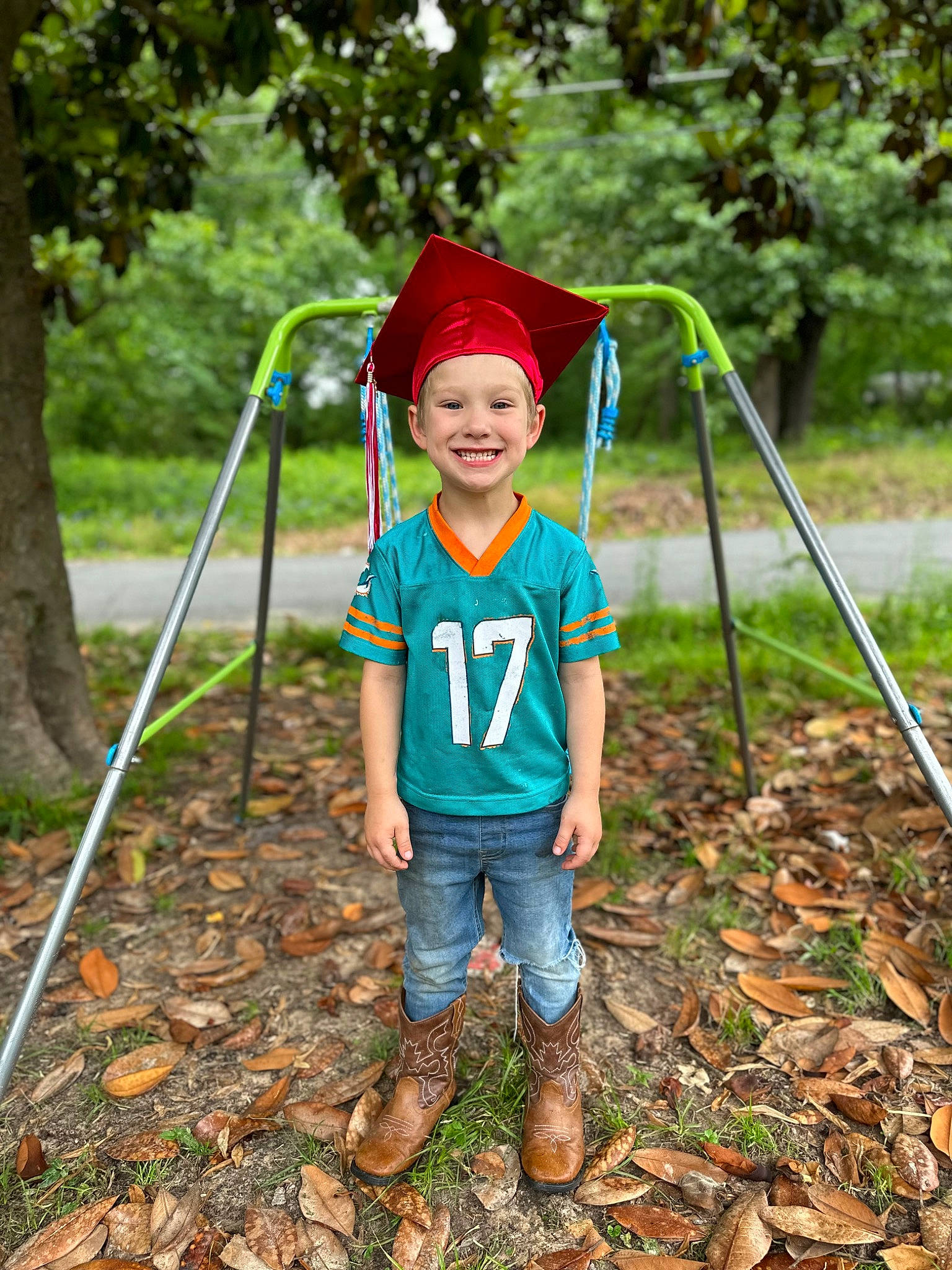 Mason is registered to the contest to win money with this photo: cap, child, eye, fun, grass, happy, hat, headwear, jeans, joy, leisure, outdoor_play_equipment, people_in_nature, person, plant, recreation, shorts, smile, soil, swing