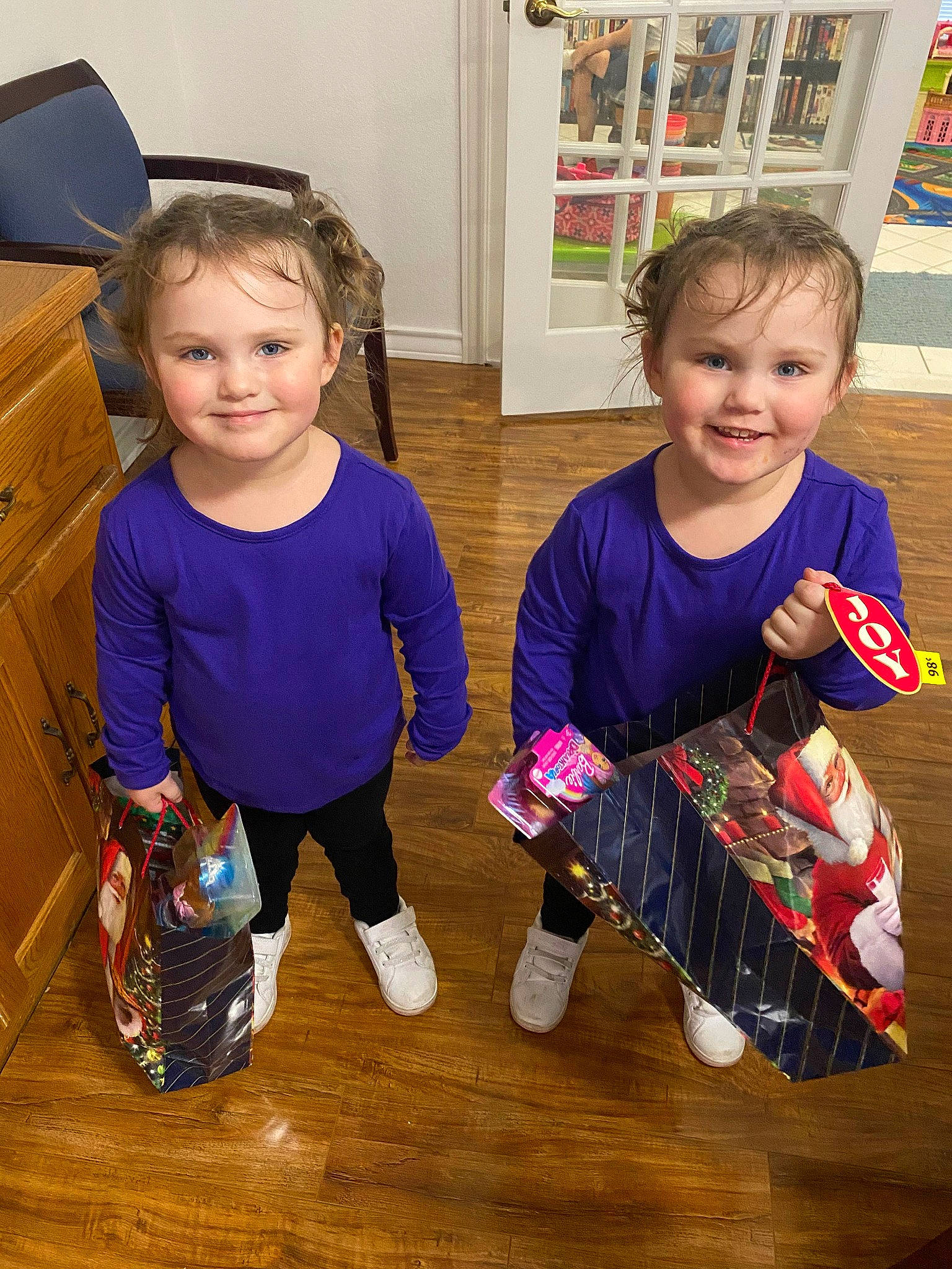 Miyah And Coraline is registered to the contest to win money with this photo: baby_toddler_clothing, bottle, child, event, flooring, fun, holiday, joy, leg, person, picture_frame, play, room, sharing, shelf, sitting, smile, standing, t_shirt, table