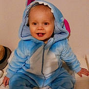 Axel participe au concours pour gagner de l'argent avec cette photo : toddler, child, smiling, costume, blue, shark, hood, teeth, sitting, bed, striped_socks, indoor, cute, happy, plush, clothing, person, face, baby, cozy