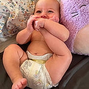 Wes joined the competition — help win amazing prizes! baby, diaper, foot, hand, face, pillow, plush_toy, purple, bed, floral_pattern, skin, cute, child, infant, smiling, lying_down, indoors, happy, toddler, playful