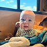 Wes is registered to the contest to win money with this photo: baby, blanket, blue_eyes, candid, child, closeup, cozy, curious_expression, face, head, indoor, infant, natural_light, portrait, sitting, soft_texture, striped_clothing, warm_tones, window, young