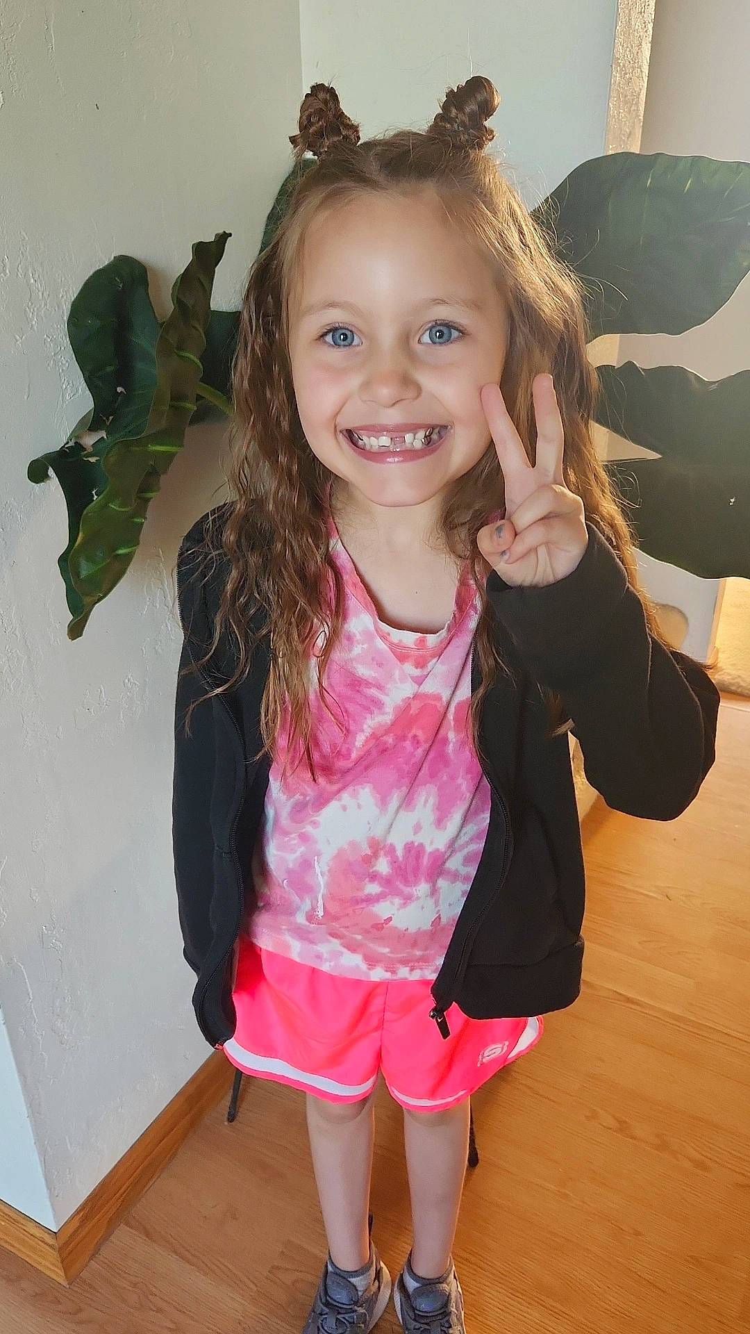 Cora is registered to the contest to win money with this photo: blond, child, eye, fun, gesture, happy, head, iris, joy, long_hair, magenta, neck, organ, person, pink, shoulder, skin, sleeve, smile, standing