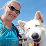 Toby is registered to the contest to win money with this photo: woman, dog, smile, sunglasses, ice_cream, outdoor, bench, blue_sky, daylight, happy, pet, leash, casual_clothing, close_up, person, animal, summer, fun, portrait, nature