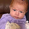Haislyn is registered to the contest to win money with this photo: baby, infant, face, purple_bow, lavender_clothing, mittens, close_up, serious_expression, blue_eyes, red_hair, indoor, portrait, child, cute, small, young, person, sitting, soft_fabric, home