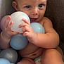 Vincent is registered to the contest to win money with this photo: baby, child, diaper, blue_eyes, plastic_balls, infant, cute, chubby, sitting, indoor, soft_chair, happy, playful, skin, hands, legs, closeup, person, toy, smiling