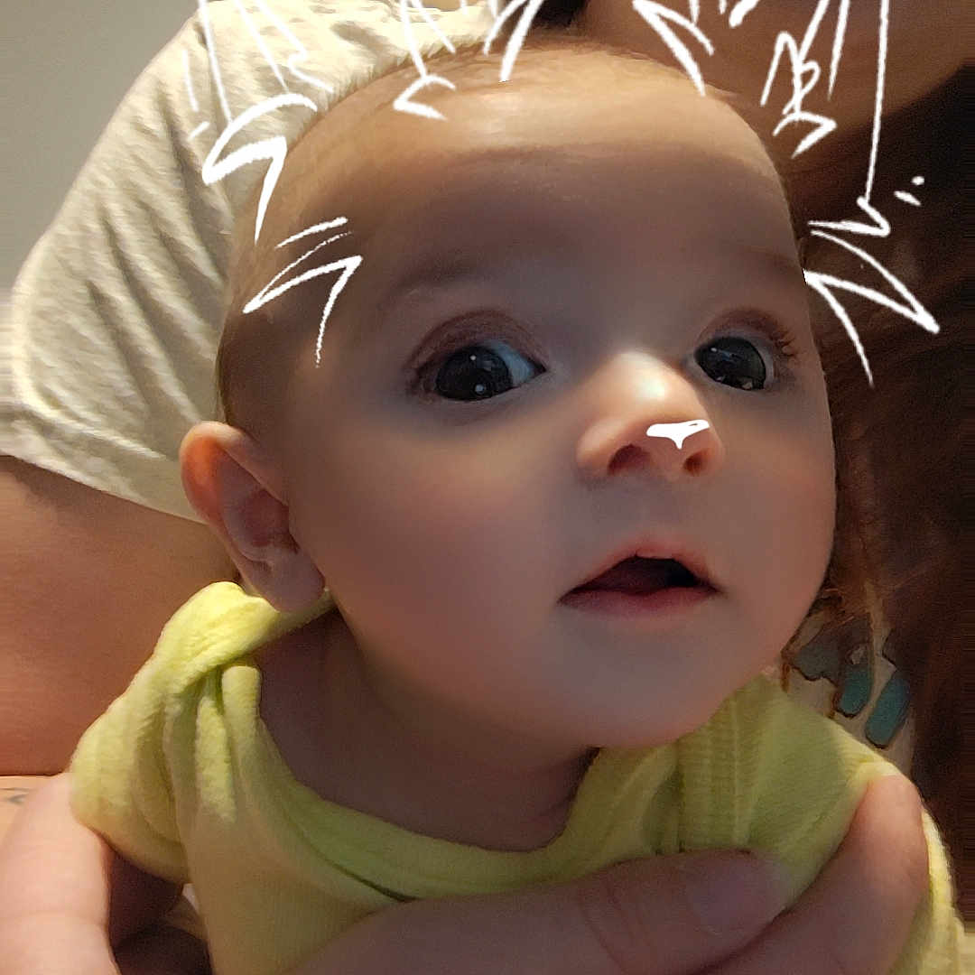 Jeydyn is registered to the contest to win money with this photo: adult, baby, cat_ears, child, closeup, cute, digital_filter, expression, eyes, face, hand, head, holding, human, indoor, mouth, person, portrait, skin, yellow_clothing