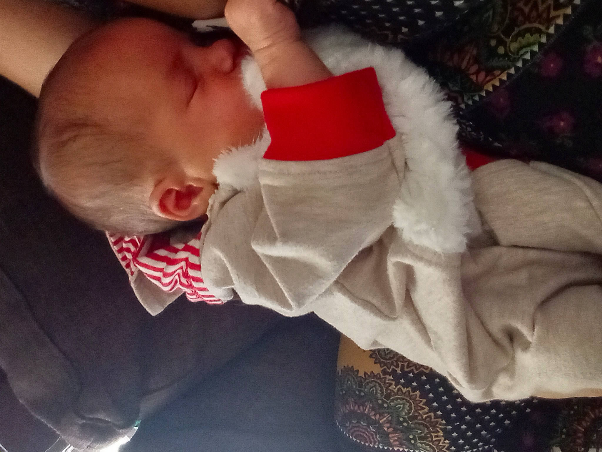 Cheryl is registered to the contest to win money with this photo: baby, baby_products, baby_sleeping, baby_toddler_clothing, carmine, cheek, child, cloud, comfort, event, eye, happy, human_body, lap, nap, nose, person, santa_claus, skin, sleeve