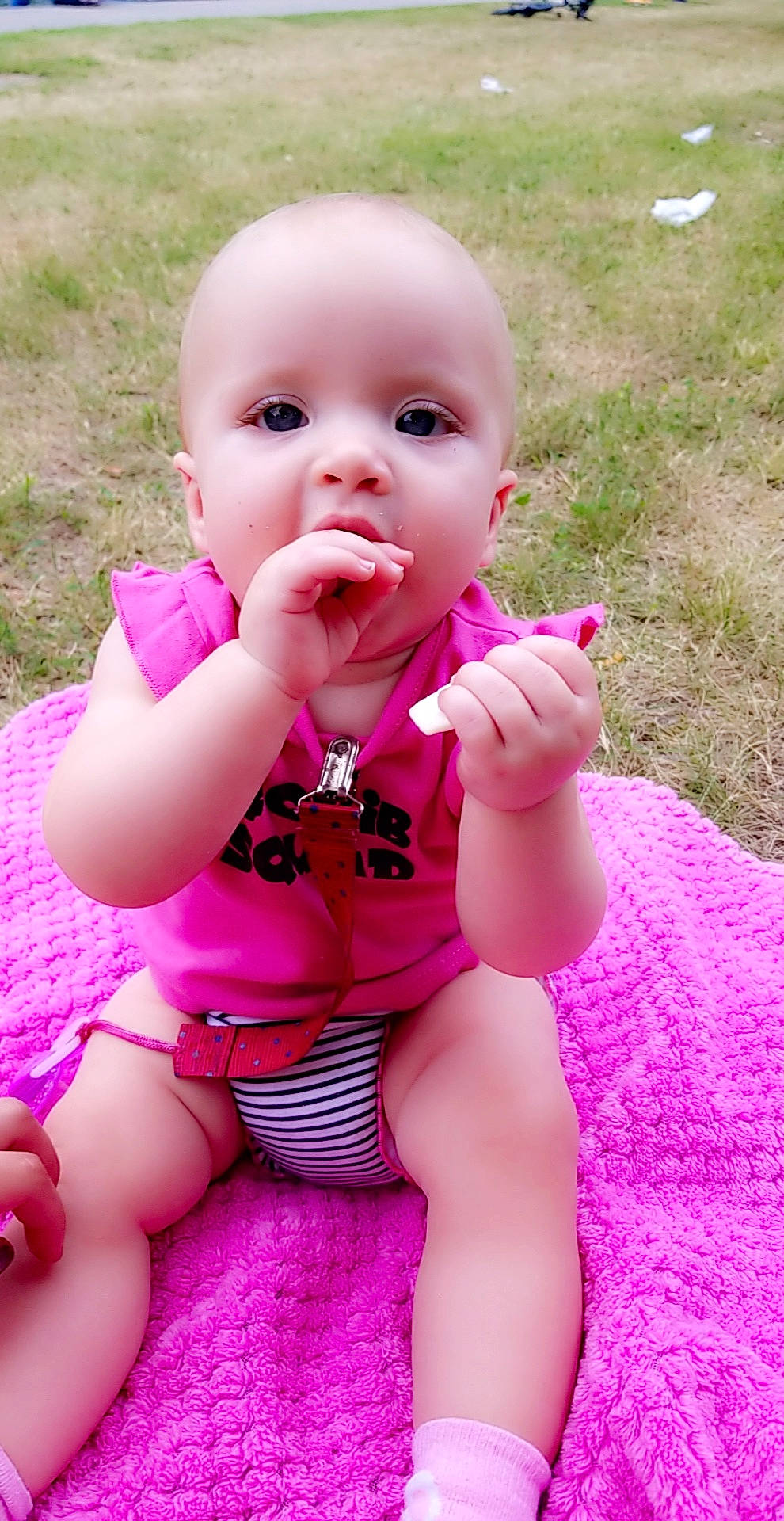 Aryanna is registered to the contest to win money with this photo: baby, baby_products, baby_toddler_clothing, cheek, child, face, finger, grass, lip, magenta, mouth, person, pink, skin, smile, toddler