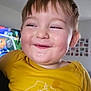 child, toddler, smiling, yellow_shirt, face, happy, indoors, home, television, wall_photos, cute, portrait, short_hair, expression, bright, clothing, person, joy, closeup, casual