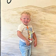 Atley joined the competition — help win amazing prizes! toddler, child, smiling, curly_hair, standing, tshirt, shorts, indoor, wall_art, blond, happy, casual_clothing, portrait, person, photo_screenshot, gallery_thumbnails, light_skin, background, text_partial, young_child