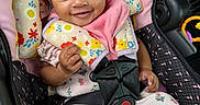 Truly is registered to the contest to win money with this photo: baby, car_seat, child, clothing, cute, eyes, fabric, floral_pattern, hand, happy, head, headband, indoors, infant, person, pink, portrait, safety, seatbelt, smile