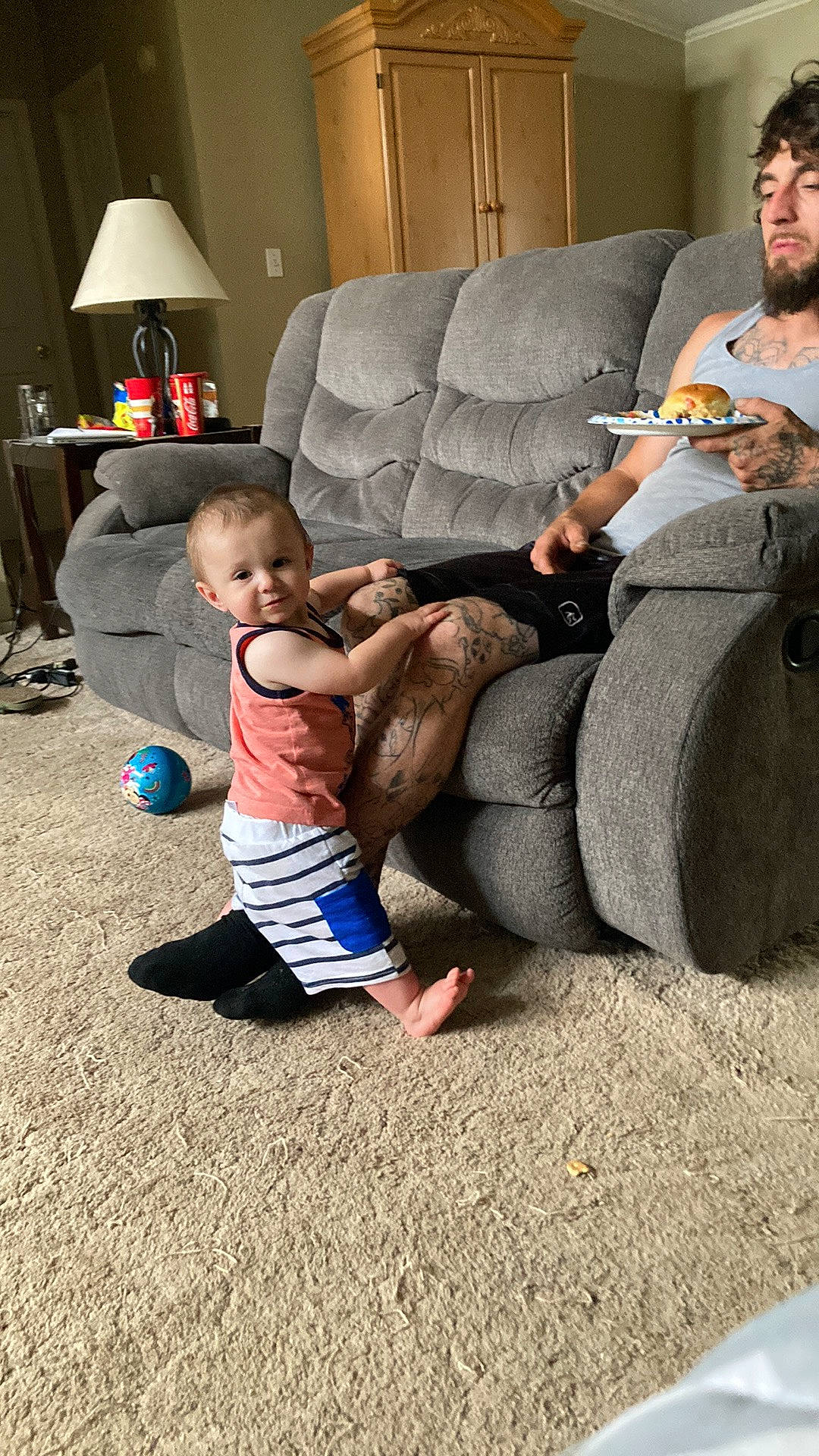 Abel is registered to the contest to win money with this photo: baby, child, comfort, couch, floor, flooring, foot, fun, human_leg, joy, knee, lamp, lap, leg, leisure, living_room, person, play, room, sitting
