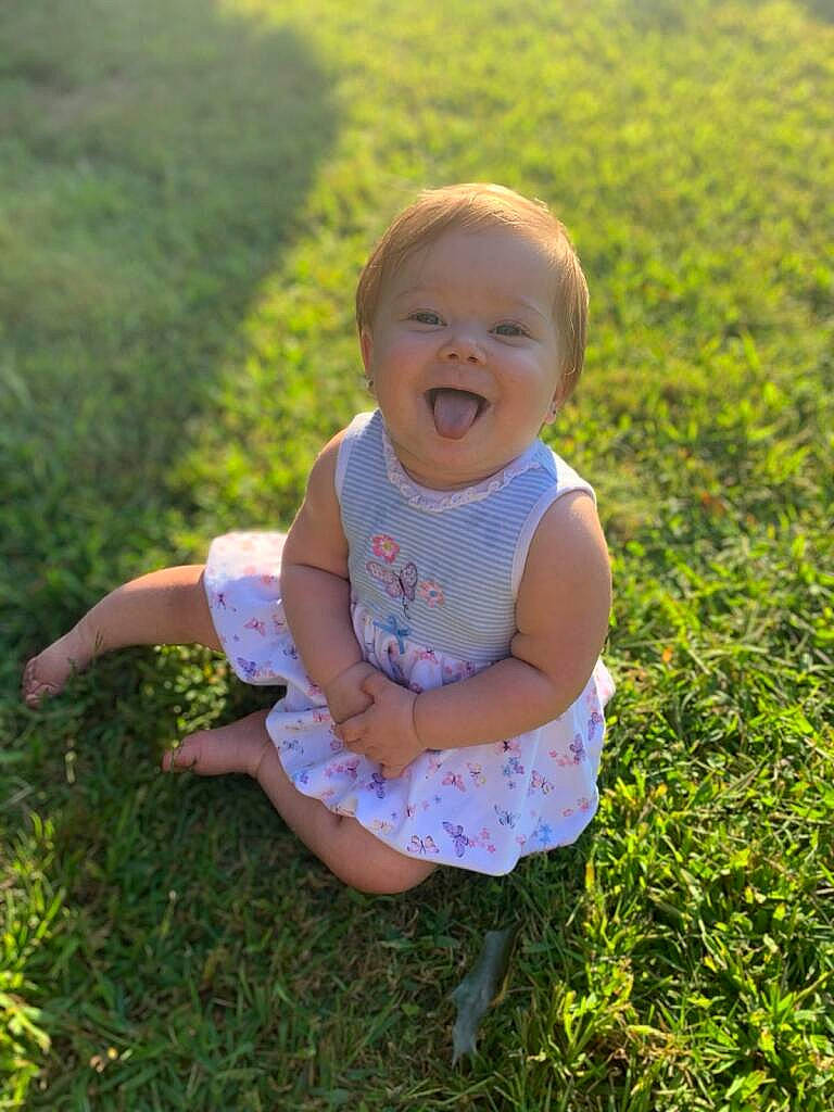 Arlyn joined the competition — help win amazing prizes! baby, baby_toddler_clothing, face, facial_expression, fun, grass, grassland, groundcover, hairstyle, happy, leaf, meadow, natural_environment, people_in_nature, person, plant, skin, smile, standing, sunlight
