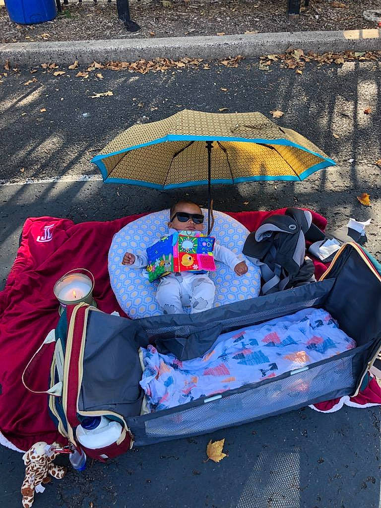 Vaeda is registered to the contest to win money with this photo: art, baby_products, bag, blue, city, comfort, fashion_accessory, leisure, motor_vehicle, people, person, plastic, recreation, road, road_surface, sidewalk, sitting, street, tints_and_shades, travel